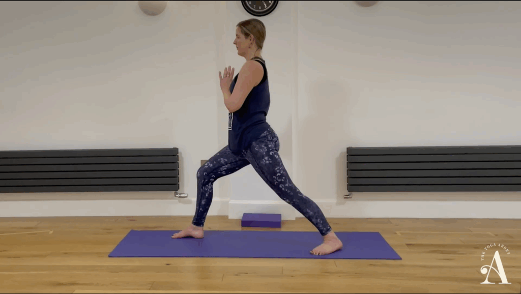 Emma Timms in Warrior 1 Pose with hands at heart center