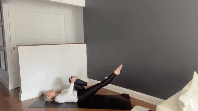 Elizabeth Miller in boat shape with one leg extended and hugging one knee